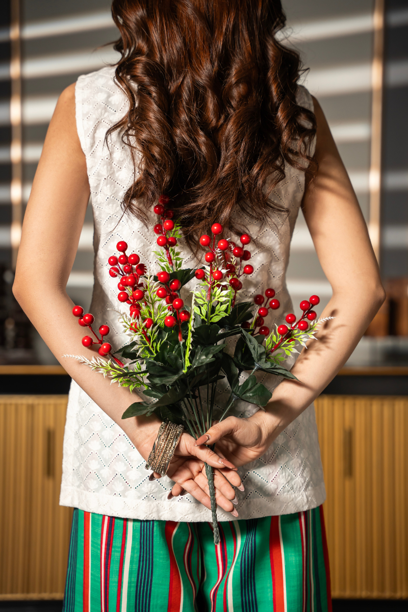 Daydream Set by Posheri, back view of white embroidered sleeveless top with green and red striped wide-leg pants, holding a bouquet