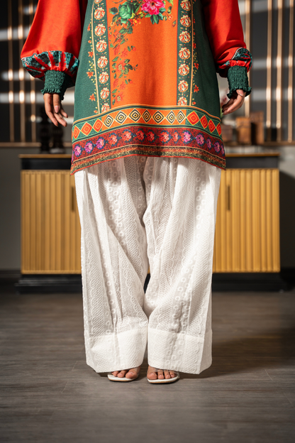 Close-up of Floral Folklore emerald green kurta showing printed hem border, orange sleeves and smocked cuffs by Posheri