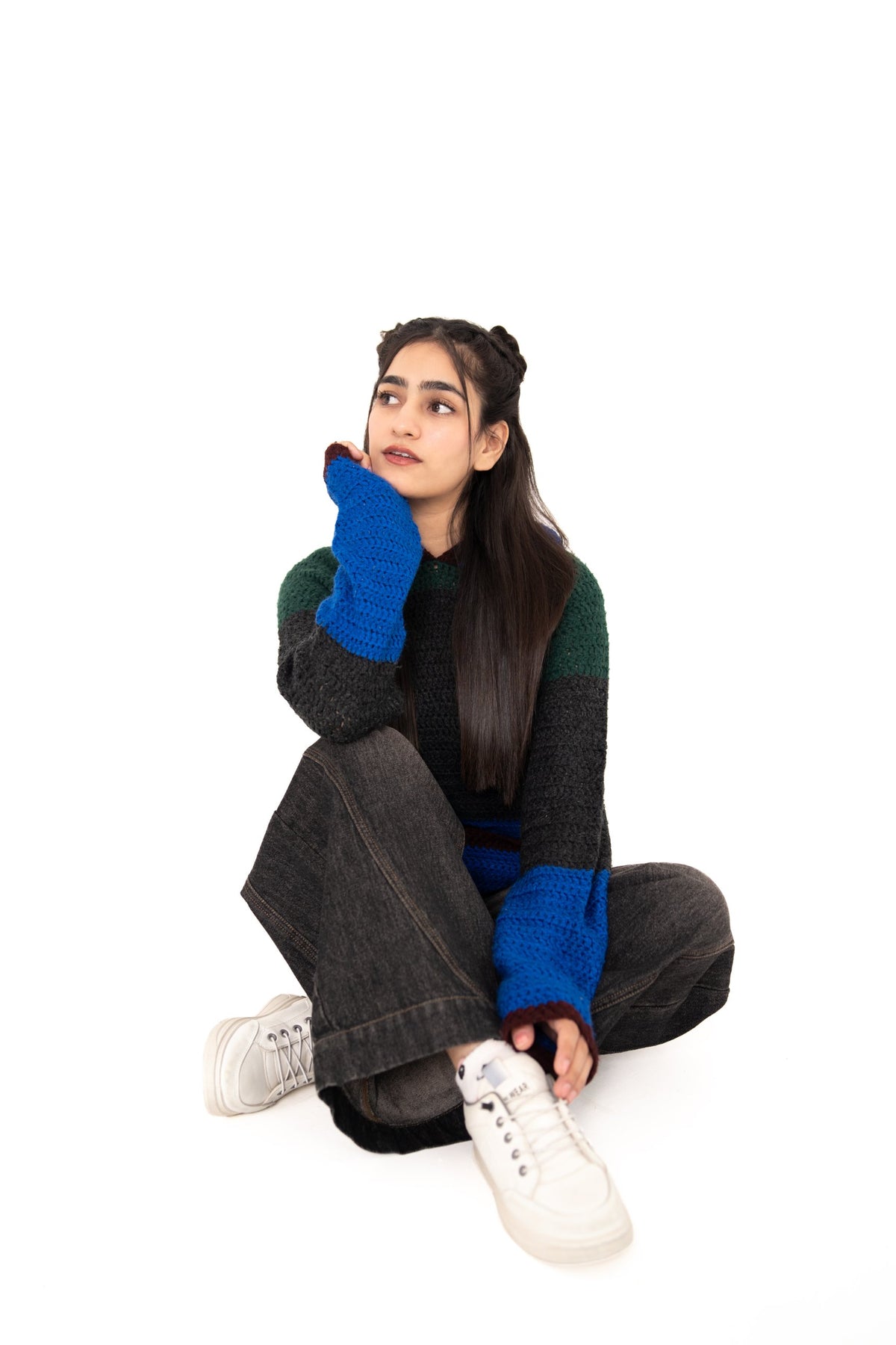Dark Mode handmade colour-block crochet hoodie in forest green, charcoal and electric blue, model seated cross-legged