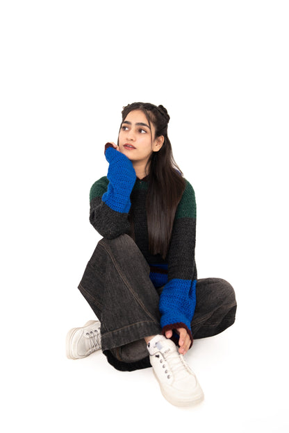 Dark Mode handmade colour-block crochet hoodie in forest green, charcoal and electric blue, model seated cross-legged