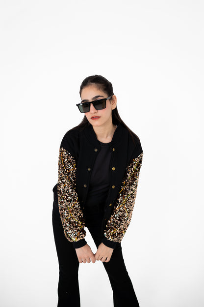 Model posing in Gilt Trip black varsity jacket with bronze-gold sequinned sleeves – POSHERI Outer Control