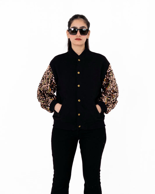 Gilt Trip black varsity jacket with bronze-gold sequinned sleeves, front view with hands in pockets – POSHERI Outer Control