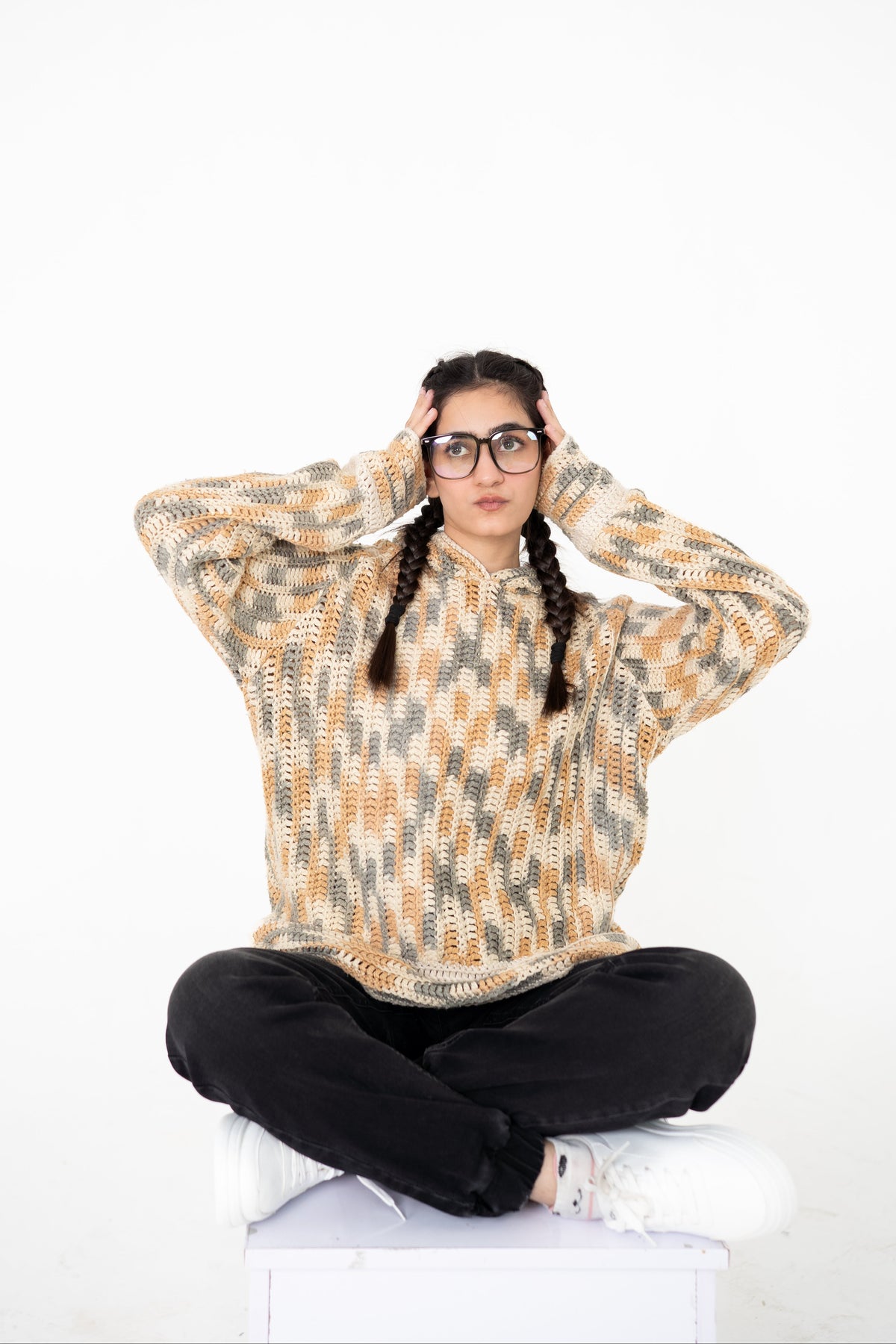 Model seated cross-legged wearing Latte Lines cream, beige and grey crochet hoodie – POSHERI Loop de Loop