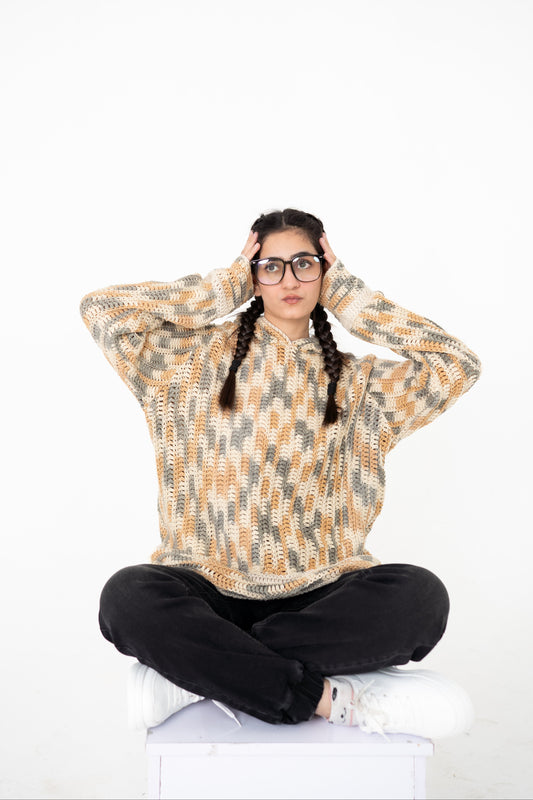 Model seated cross-legged wearing Latte Lines cream, beige and grey crochet hoodie – POSHERI Loop de Loop