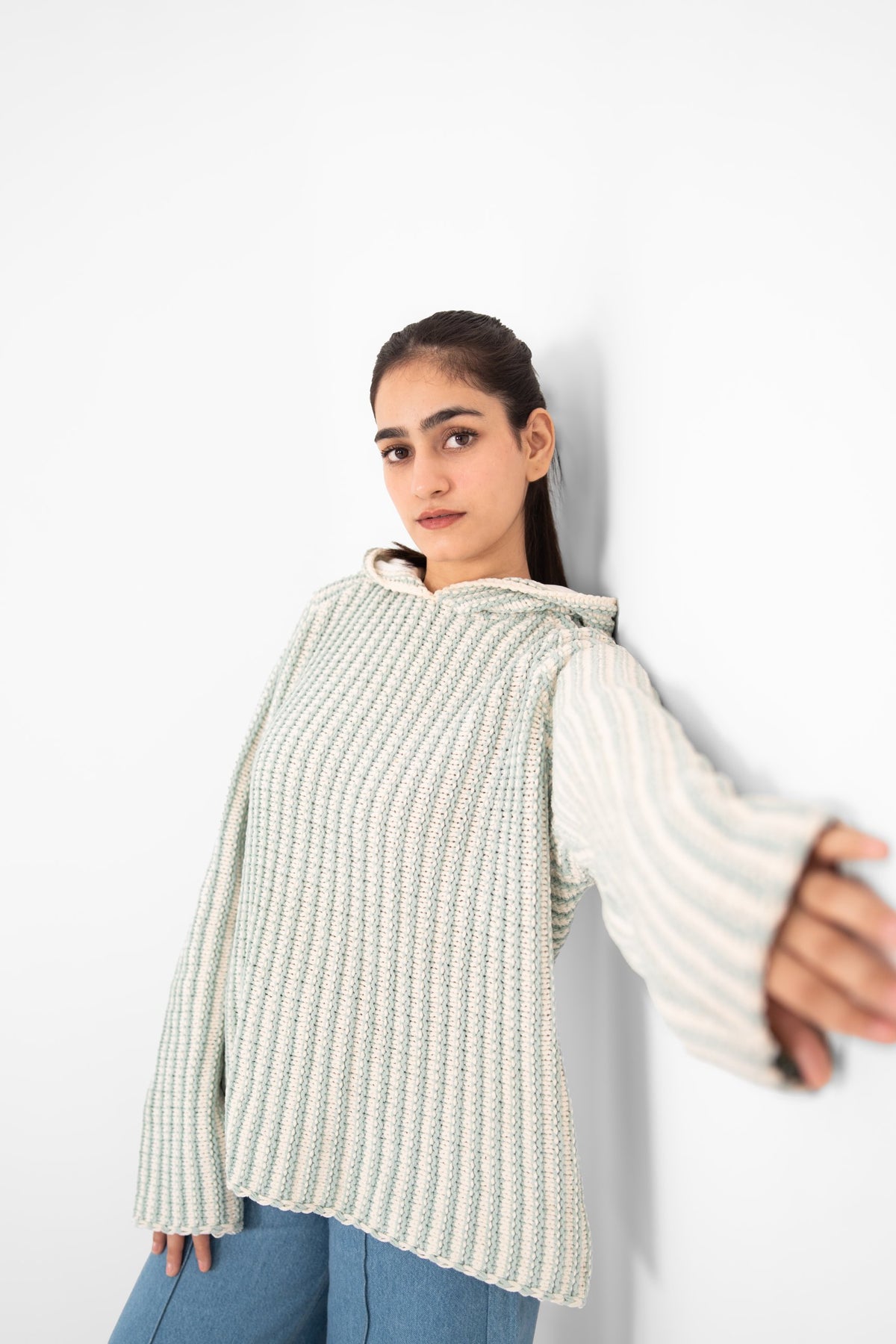 Mint Condition handmade mint and ivory ribbed crochet hoodie, model leaning against a white wall