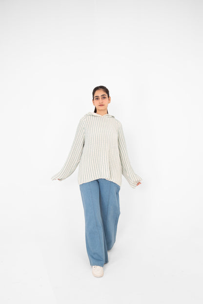 Mint Condition relaxed-fit crochet hoodie with flared sleeves, model walking in light blue wide-leg jeans