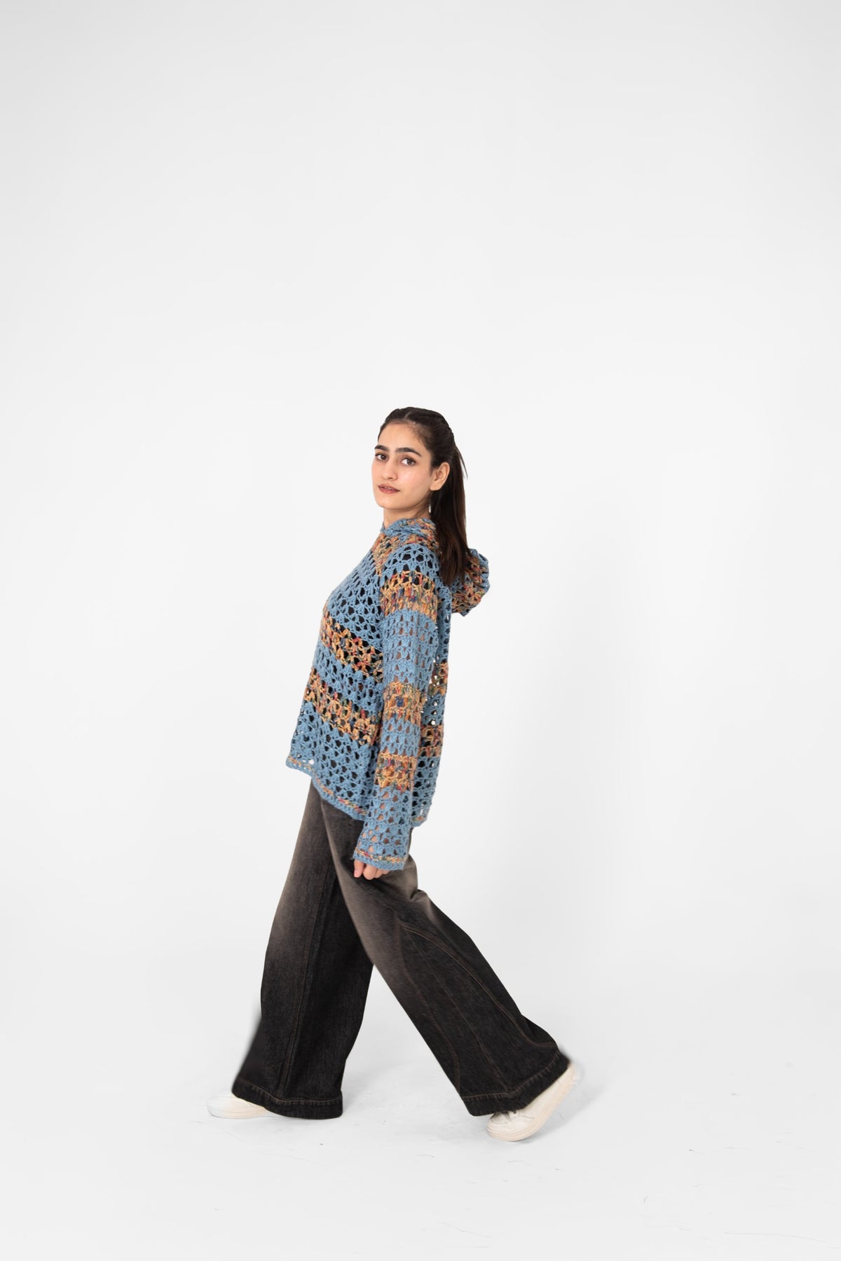 Mosaic Mood openwork crochet hoodie side view, model walking in wide-leg washed black jeans