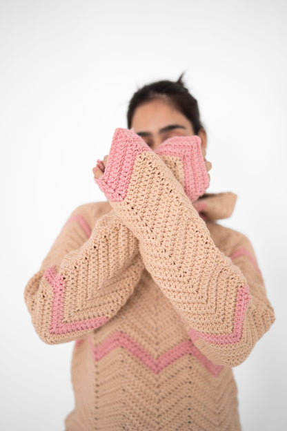 Model holding the pink cuffs of the Pink Plot Twist beige and pink chevron crochet hoodie to her face – POSHERI Loop de Loop