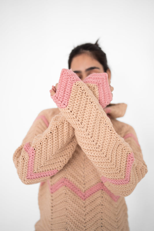 Model holding the pink cuffs of the Pink Plot Twist beige and pink chevron crochet hoodie to her face – POSHERI Loop de Loop