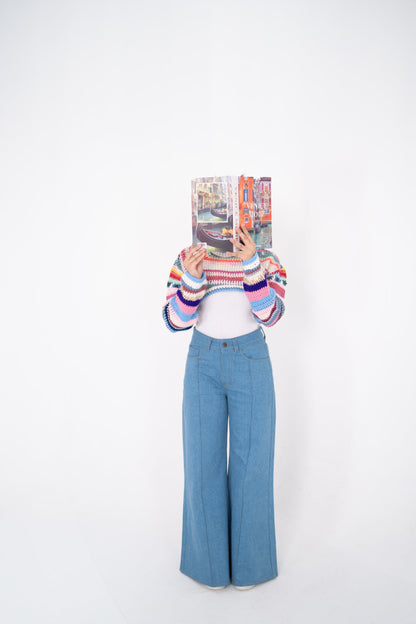 Short Circuit cropped crochet top front view, model holding a book in front of her face