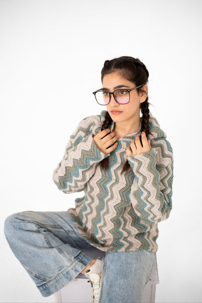 Model seated wearing Tidal Shift sage and blue chevron crochet hoodie – POSHERI Loop de Loop